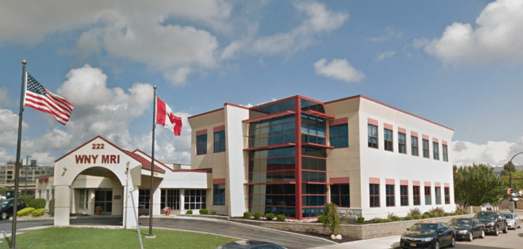 Medical office building against a blue sky with flags in front